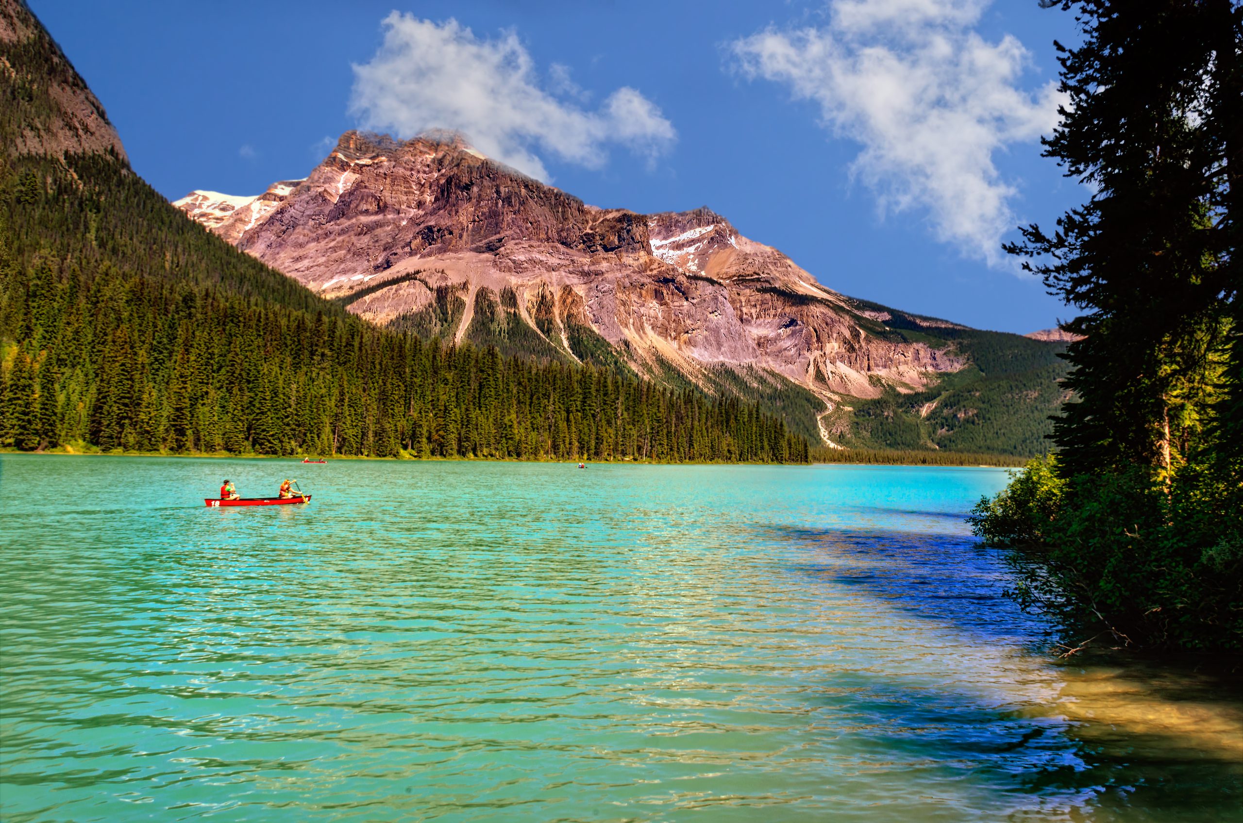 emerald-green-lake-surrounded-by-coniferous-forests-and-rocky-m
