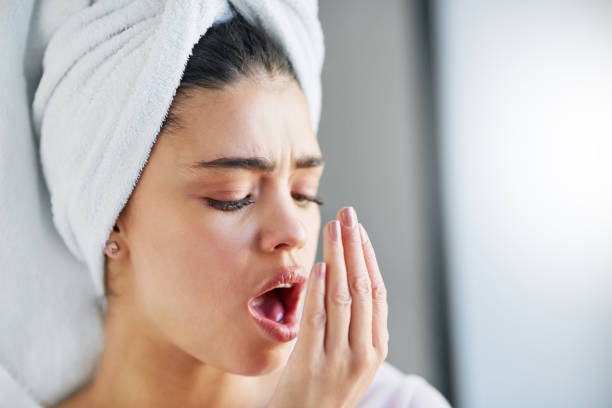 shot-of-a-beautiful-young-woman-checking-her-breath-at-home