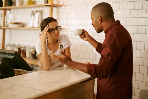 shot-of-a-young-woman-serving-a-difficult-customer-in-a-coffee-shop