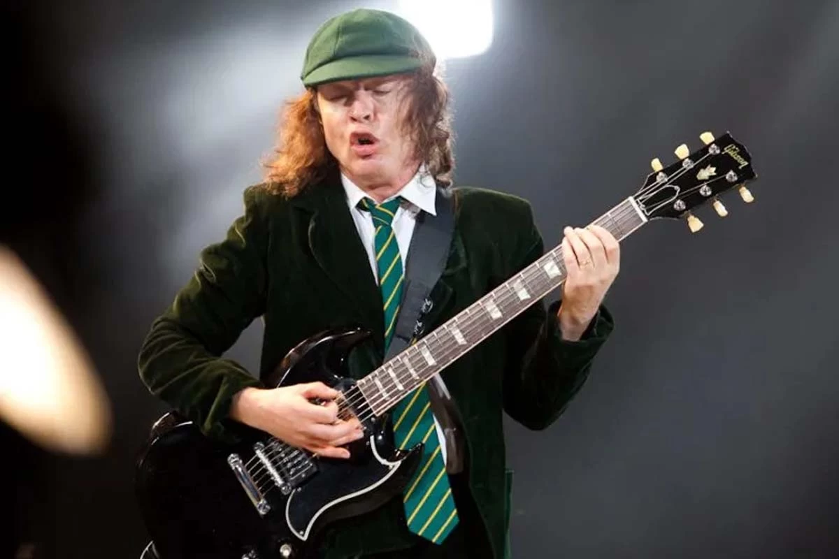 angus-young-on-stage-green-cap-blazer-tie-black-guitar