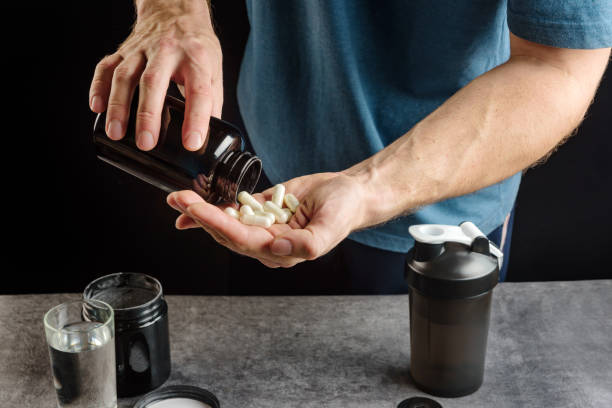 athlete-takes-supplements-capsules-with-amino-acid-on-the-palm-close-up