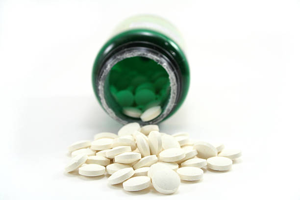 folic-acid-pills-spilled-from-their-bottle-against-a-white-background