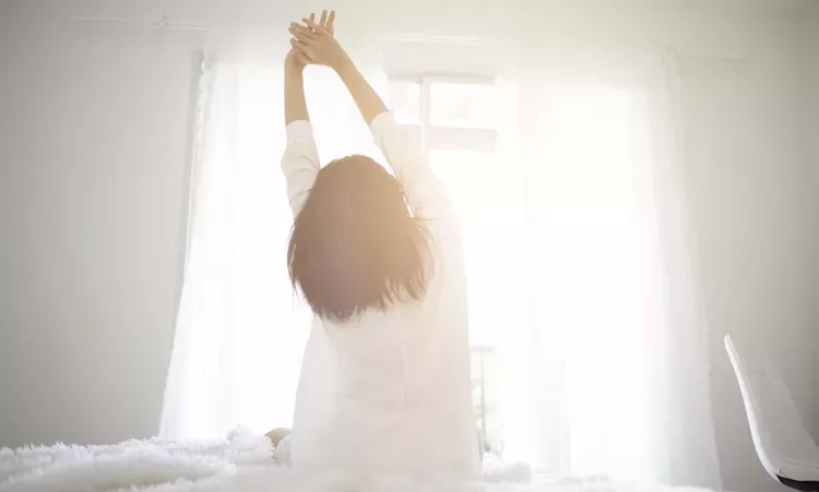 woman-waking-up-sunlight-0518-047eb9af0b154cefa9f56536a2b6ea76