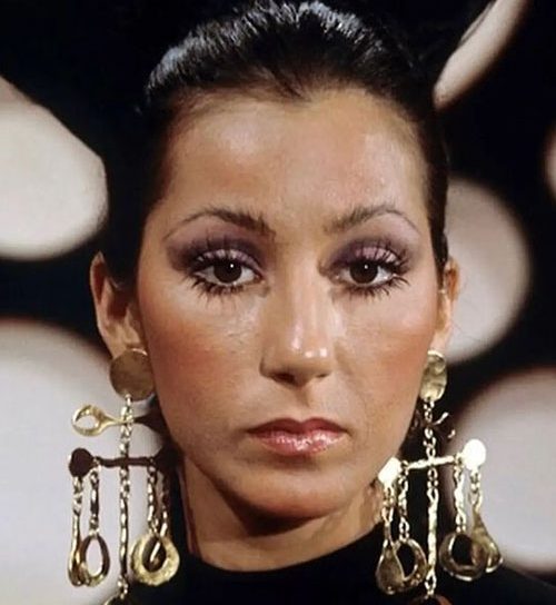 cher-posing-with-long-lashes-and-golden-earrings