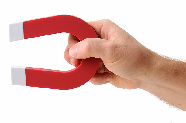 a-hand-holding-a-magnet-isolated-on-white-to-pick-up-an-object
