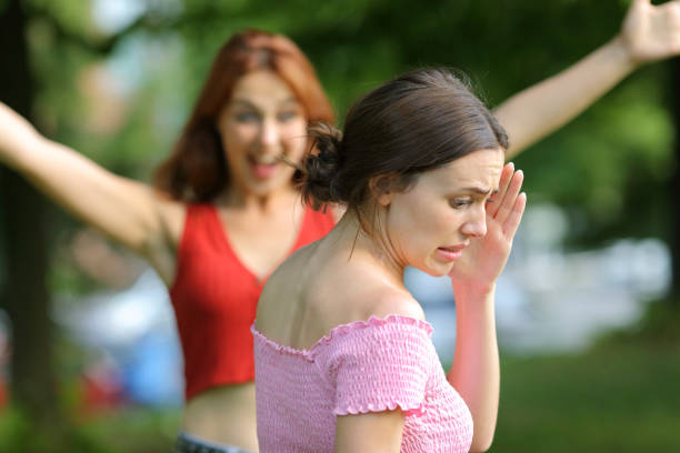 stressed-woman-avoiding-to-meet-her-friend-in-a-park