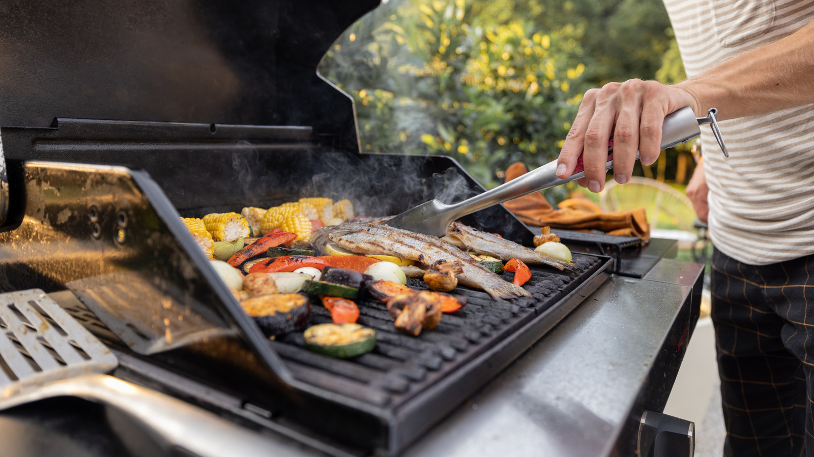 peoplegrillingfishandcornonamoderngrilloutdoors
