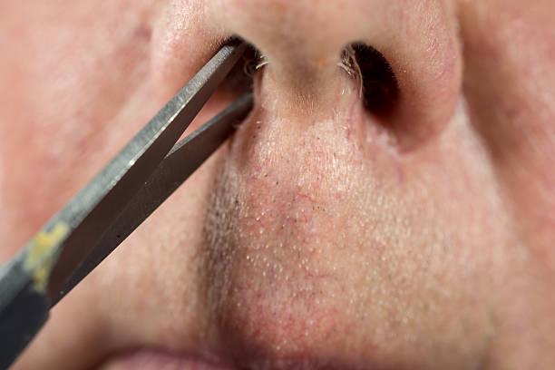 a-senior-man-trimming-the-hair-in-his-nose-close-up