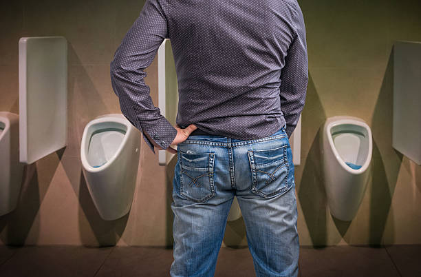 standing-man-peeing-to-a-urinal-in-restroom-or-incontinence-concept