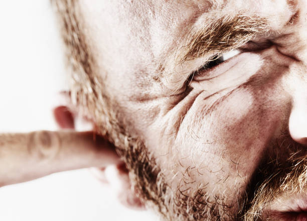 cropped-close-up-of-a-mature-man-grimacing-as-he-scratches-and-rubs-at-his-ear