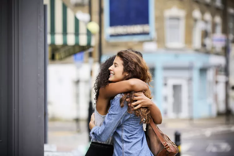 two-women-hugging-outside-511069785-a03ca9f889394eb6be86f0abd58353fd
