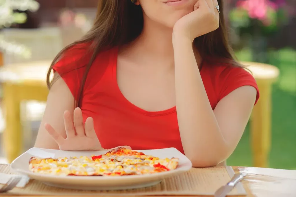 woman-pushing-plate-pizza-away-skip-meal