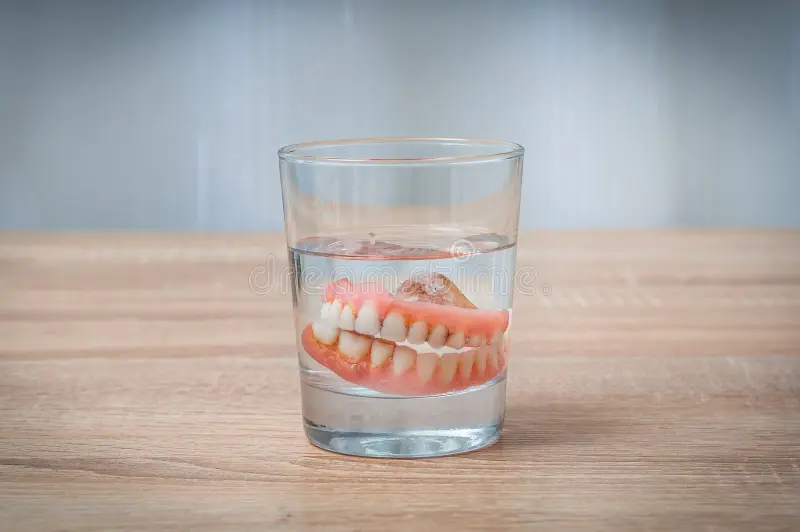 false-teeth-swim-transparent-water-glass-dental-concept-78767007