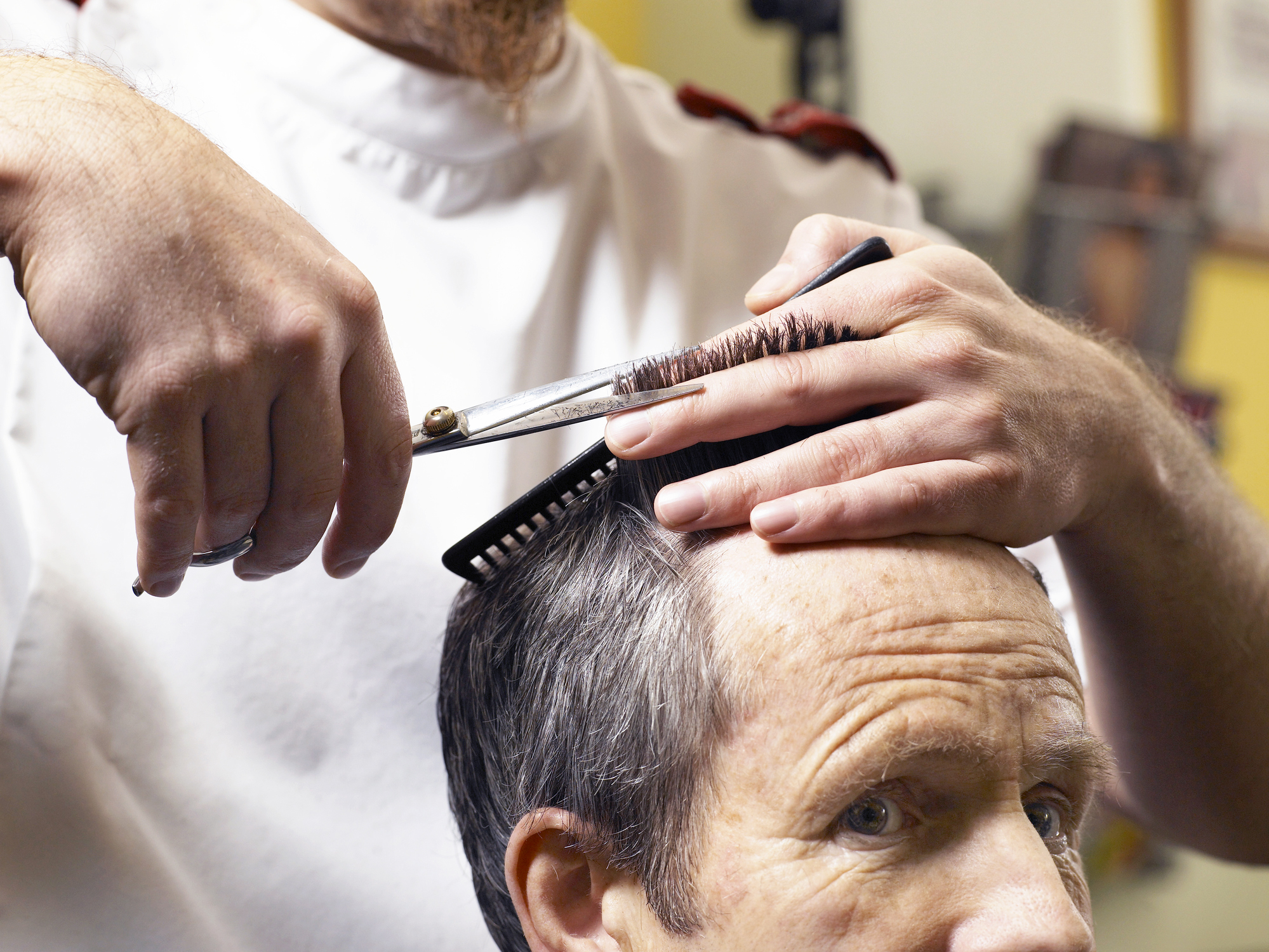 barber-cutting-senior-mans-hair-close-up-of-hands