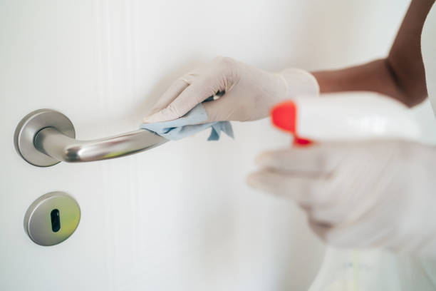 female-hands-with-protection-glove-wiping-door-handle-with-disinfectant