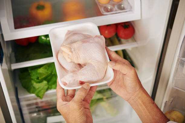 man-taking-package-of-fresh-chicken-thights-out-of-refrigerator