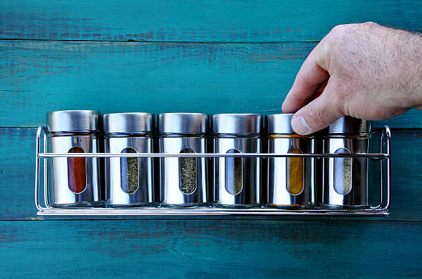 chef-hand-returning-spice-into-a-spice-rack-food-background-copy-space